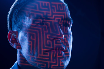 Gedanken als Konzept durch ein Labyrinth auf dem Gesicht eines konzentrierten Denkers symbolisiert