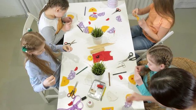 Girls at the lesson with the teacher sew a soft toy with their own hands