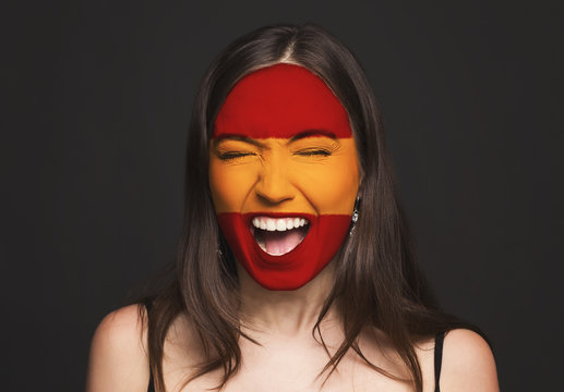 Young woman with Spain flag painted on her face