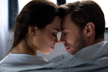 Romantic man and woman tenderly embracing in bedroom