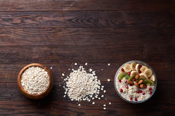 Diet breakfast oatmeal with fruits and bowl with oat flakes, selective focus, close-up