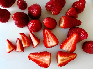 Erdbeeren geschnitten und ganz auf weißem Hintergrund