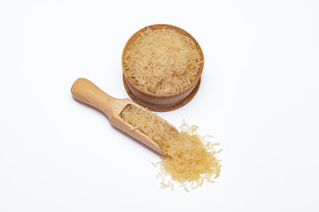 Rice in a wooden bowl and in a wooden scoop on a white background.