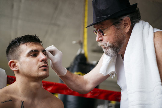 Medic examining eye of boxer