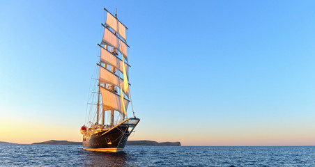 Naklejka premium Sailing ship and beautiful sunset in the sea. Yachting. Sailing