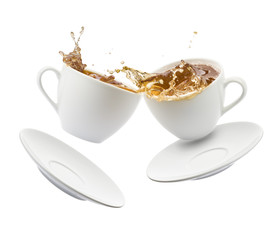 two cup of tea jumps and clash with splashing on white background