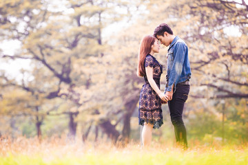 Portrait asian couple loving under tree in park