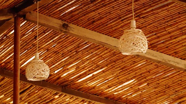 Decorating hanging wicker lantern lamps woven basket and wooden celling in interior outdoor cafe. Looping video