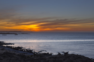Wind swept clouds colored by setting sun