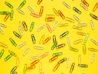 Business flat lay with copy space Stationery colored paper clips yellow background