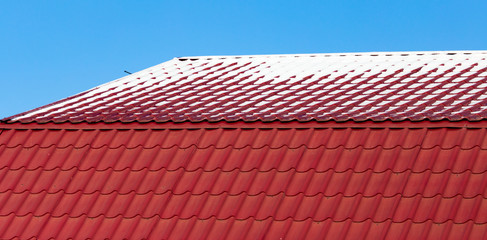 Snow on the roof of the house in winter
