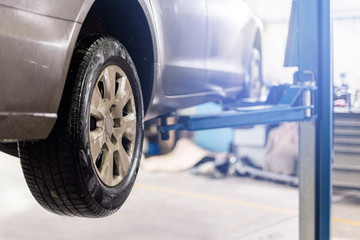 Car at service center. Vehicle raised on a lift. Check up, maintenance and repair concept