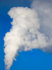 Obraz premium smoke from a pipe in the factory against a blue sky