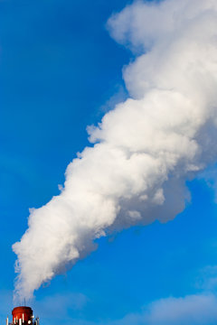 smoke from a pipe in the factory against a blue sky