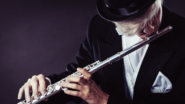 Elegantly dressed male musician playing flute