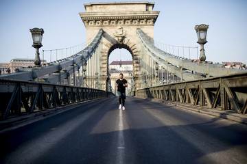 Young man running on Chain bridge in Budapest, Hungary
