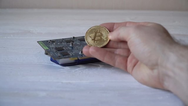 Golden Bitcoin in a man's hand. Symbol of a new virtual currency