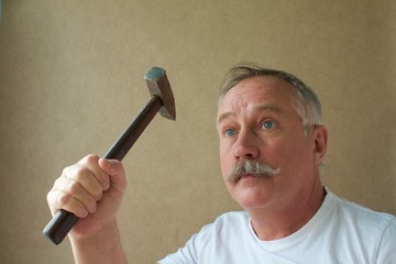 gray-haired mustachioed master with a hammer in his hand