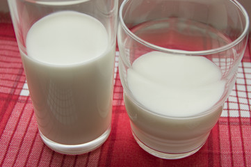 Two glasses of milk on a red checkered cloth, healthy food concept