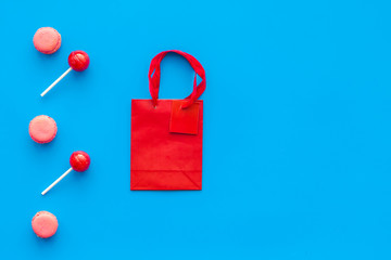 Gift concept. Sweets, paper bag for gift on blue background top view mock up