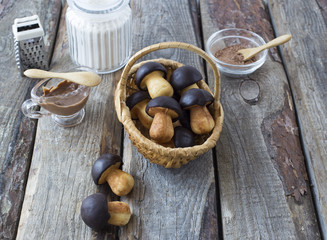 Fototapeta premium on the table flour, chocolate and biscuits in the form of mushrooms in a basket