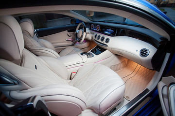 Luxury car interior. Steering wheel, shift lever and dashboard.
