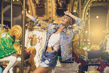 Stylish woman wearing sparkling jacket on the carousel