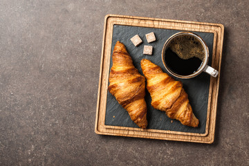 Morning black coffee with croissants on serving board
