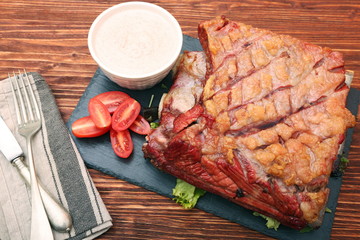 Delicious smoked beef ribs on an old rustic wooden chopping boar