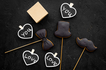Gift for man on birthday. Gift box among cookies in shape of moustache, hat, bow tie and hearts...