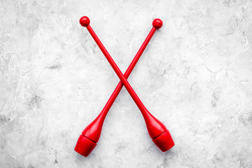 Maces for rhythmic gymnastics on grey background top view copy space