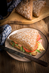 Triangular sandwich with cheese, ham and tomato.