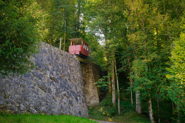 Red car of a tourist train. funicular cabin rides up. Switzerland, the road to the Reichenbach Falls. Tourist transport for uphill climbing
