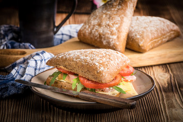 Triangular sandwich with cheese, ham and tomato.