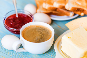 Breakfast with coffee, eggs, toasts, cheese, jam