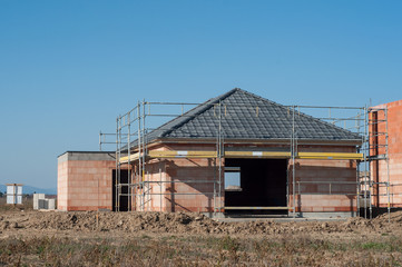 retail of brick house under construction on blue sky background