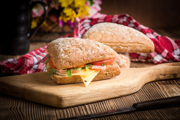 Triangular sandwich with cheese, ham and tomato.