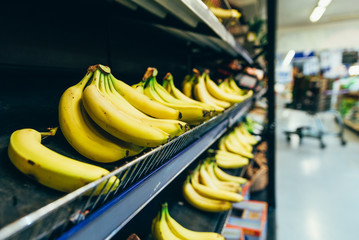 yellow bananas on store shelf. fruits grocery shopping