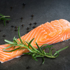 Delicious portion of fresh salmon fillet with aromatic herbs, spices and vegetables - healthy food, diet or cooking concept