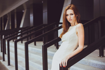 Young beautiful girl with a brown-haired woman in a beige dress, walking, walking along a street, a city and posing. Fashion photo