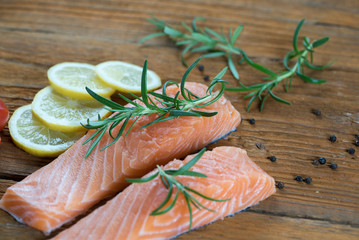 Salmon Fish..Raw salmon fillet pepper salt dill lemon rosemary on wooden table.. close up