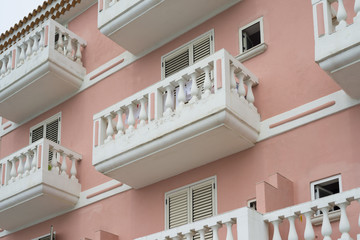 Weiße Balkone und Fensterläden an einer Lachs-farbigen Fassade eines Mittelmeer-Hauses im Cilento...