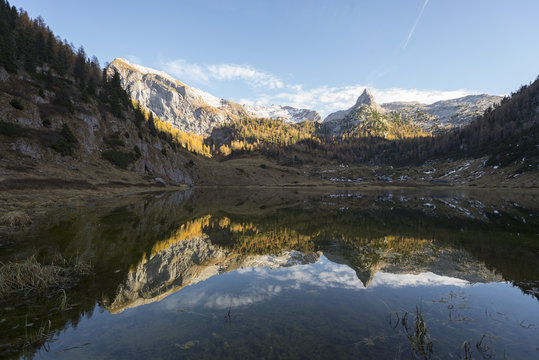 Herbstliche Bergw&auml;lder und schneebdeckte Berggipfel in der Abendsonne spiegeln sich im stillen Funtensee in den Bergen des Nationalpark Berchtesgaden, Bayern, Deutschland