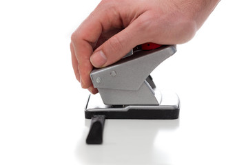 Puncher used by a male hand against a white background