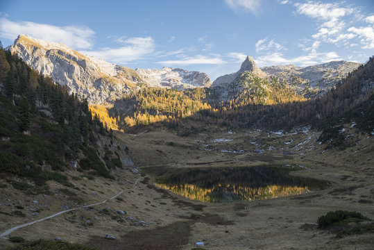 Herbstliche Bergw&auml;lder und schneebdeckte Berggipfel in der Abendsonne spiegeln sich im stillen Funtensee in den Bergen des Nationalpark Berchtesgaden, Bayern, Deutschland