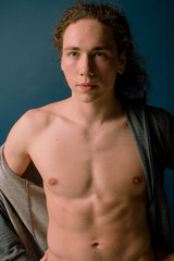 Naklejka premium Attractive and stylish guy with curly hair and a sports figure