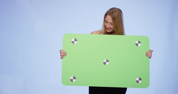 Cheerful Woman holding oversized blank Card and looking at it
