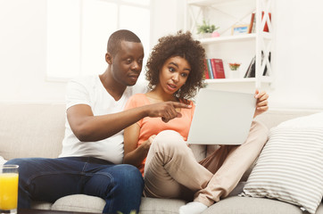Young african-american couple working on laptop