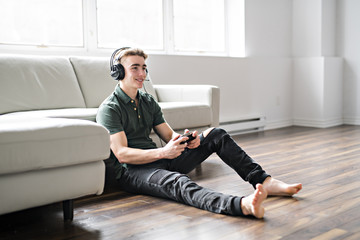 Young attractive man playing video games in the livingroom
