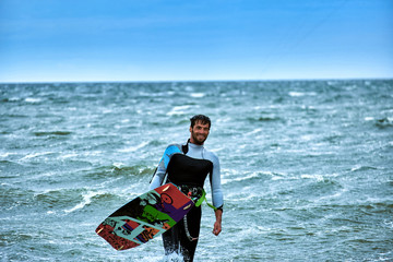 Obraz premium Man riding a kite surfing on the waves in the summer.